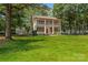Charming two-story home with a large front yard, a red front door and a double-decker porch, perfect for relaxing outdoors at 1282 W Highway 27 Hwy, Lincolnton, NC 28092