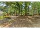 A sprawling backyard with mature trees, a play area, and various outbuildings for storage at 1282 W Hwy 27 Hwy, Lincolnton, NC 28092
