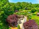 Beautiful aerial view of a community space with lush landscaping, a pond with a fountain, and outdoor seating at 1313 Haywood Park Rd, Marvin, NC 28173