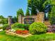 Stone entrance sign to The Courtyards at Marvin with colorful flower beds and lush green landscaping at 1313 Haywood Park Rd, Marvin, NC 28173
