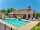 Community pool with lounge chairs, tables, and chairs surrounded by well-maintained landscaping at 1313 Haywood Park Rd, Marvin, NC 28173