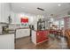 Bright kitchen featuring white cabinetry, dark countertops, an island, and adjacent dining area with lake views at 141 Badin Lake Cir, New London, NC 28127