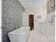 Modern bathroom featuring a freestanding tub, stone accent wall, and sauna entrance at 15020 Ranson Rd, Huntersville, NC 28078