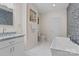 Bright bathroom features a modern freestanding tub, vanity with granite countertop, and modern fixtures at 15020 Ranson Rd, Huntersville, NC 28078