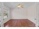 Bedroom with hardwood floors, ceiling fan, and large window with natural light at 15020 Ranson Rd, Huntersville, NC 28078