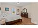 Cozy bedroom with hardwood floors, white linens, dark wood furniture, and a bright window at 15020 Ranson Rd, Huntersville, NC 28078