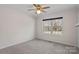 Bedroom with neutral carpet, ceiling fan, trim, and a large window overlooking the yard at 15020 Ranson Rd, Huntersville, NC 28078