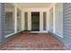 Charming front porch with brick flooring, gray siding and a stylish front door at 15020 Ranson Rd, Huntersville, NC 28078