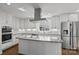 Bright kitchen with white cabinets, stainless steel appliances, granite countertops, and a stylish range hood at 15020 Ranson Rd, Huntersville, NC 28078