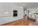Kitchen with hardwood floors, white cabinets, stainless steel appliances and view to living space at 15020 Ranson Rd, Huntersville, NC 28078