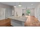 Open floor plan with granite countertop island, hardwood floors, and sliding doors to deck at 15020 Ranson Rd, Huntersville, NC 28078