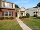 Charming home with a brick accent wall, manicured lawn, and inviting walkway leading to the front door at 1573 Maypine Commons Way, Rock Hill, SC 29732