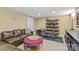 Finished basement area with leather couch, gym equipment, tile flooring, and neutral walls at 1619 Providence Rd, Charlotte, NC 28207