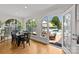 Bright dining area with pool view, hardwood floors, modern arched windows, and sleek black dining set at 1619 Providence Rd, Charlotte, NC 28207