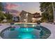 Beautiful in-ground pool and spa with an outdoor dining area, all illuminated at dusk at 1619 Providence Rd, Charlotte, NC 28207