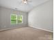 Spacious bedroom with neutral carpet, ceiling fan, and natural light at 1660 Beleek Ridge Ln, Lake Wylie, SC 29710