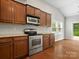 Well-equipped kitchen featuring stainless steel appliances, wooden cabinets, and a view of the backyard at 1660 Beleek Ridge Ln, Lake Wylie, SC 29710