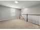 Spacious loft with carpet, window, and staircase with white railing at 1660 Beleek Ridge Ln, Lake Wylie, SC 29710