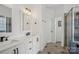 Bright bathroom with double sinks, white cabinets, white marble countertops and tiled floors at 175 Turnberry Ln, Mooresville, NC 28117