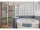 Bathroom featuring a white tub, glass shower and bright window at 175 Turnberry Ln, Mooresville, NC 28117