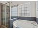 Bathroom featuring a white tub, glass shower and bright window at 175 Turnberry Ln, Mooresville, NC 28117