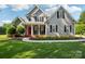 Charming two-story home with a landscaped yard, red door, and inviting front porch at 175 Turnberry Ln, Mooresville, NC 28117