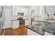 Well-lit kitchen boasts stainless steel appliances, granite countertops, white cabinets and hardwood floors at 175 Turnberry Ln, Mooresville, NC 28117