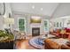 Cozy living room featuring a fireplace, large windows, and hardwood floors at 175 Turnberry Ln, Mooresville, NC 28117