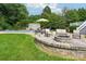 Landscaped patio with outdoor seating, fire pit, and a view of the pool and backyard at 175 Turnberry Ln, Mooresville, NC 28117