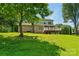 Spacious backyard with a deck, brick house, and mature tree providing shade at 176 Sharon Valley Dr, Hickory, NC 28601