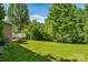 Lush backyard with a deck, mature trees, and green grass, ideal for outdoor activities and gatherings at 176 Sharon Valley Dr, Hickory, NC 28601