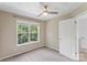 Neutral bedroom featuring a ceiling fan, window overlooking lush greenery, and a convenient door at 176 Sharon Valley Dr, Hickory, NC 28601