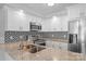 Updated kitchen features white cabinets, stainless steel appliances, granite countertops, and decorative tile backsplash at 176 Sharon Valley Dr, Hickory, NC 28601