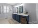 Bathroom featuring a double vanity with a quartz countertop and decorative plants at 1826 Hall Ave, Charlotte, NC 28205