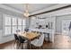 Elegant dining area features a decorative chandelier and transitions to a modern, all-white kitchen at 1826 Hall Ave, Charlotte, NC 28205