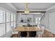 Dining room featuring a modern chandelier, wood dining table, and kitchen access, with natural light at 1826 Hall Ave, Charlotte, NC 28205