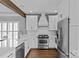 Modern kitchen featuring stainless steel appliances, white cabinets, quartz countertops, and hardwood floors at 1826 Hall Ave, Charlotte, NC 28205