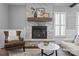 Bright living room featuring a stone fireplace with a wooden mantel, hardwood floors, and comfortable seating at 1826 Hall Ave, Charlotte, NC 28205