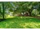 Spacious backyard with lush lawn, mature trees, and playhouse at 2131 Lee St, Gastonia, NC 28054