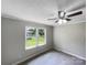 Cozy bedroom with soft carpet, ceiling fan, and a well-lit window overlooking the outdoors at 2136 W 6Th Ave, Gastonia, NC 28052