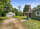 Charming home exterior with a detached garage, green siding, and inviting front porch at 2136 W 6Th Ave, Gastonia, NC 28052