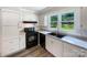 Updated kitchen with white cabinetry, black appliances, and a window overlooking the backyard at 2136 W 6Th Ave, Gastonia, NC 28052