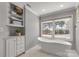 Bright bathroom with a freestanding tub and large windows overlooking a tree-filled backyard at 22 Honeysuckle Ln, Clover, SC 29710