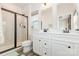 Bright bathroom featuring double sinks, granite countertops, and a tiled shower with glass doors at 2203 Autumn Olive Ln, Stallings, NC 28104