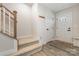 Inviting foyer featuring carpeted stairs, coat hooks, and front door at 2203 Autumn Olive Ln, Stallings, NC 28104