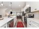 Modern kitchen featuring stainless steel appliances, white cabinetry, quartz counters, and an open layout at 2203 Autumn Olive Ln, Stallings, NC 28104