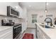 Bright view of kitchen with modern appliances, white cabinets, a sleek countertop, and a window view at 2203 Autumn Olive Ln, Stallings, NC 28104
