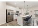 Bright kitchen with stainless steel appliances, white cabinetry, an island, and modern pendant lighting at 2203 Autumn Olive Ln, Stallings, NC 28104
