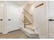 Bright entryway featuring carpeted stairs with wooden banister and coat rack at 2203 Autumn Olive Ln, Stallings, NC 28104