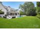 Expansive backyard featuring a sparkling pool, covered patio, and lush green lawn perfect for outdoor living at 2215 Cortelyou Rd, Charlotte, NC 28211